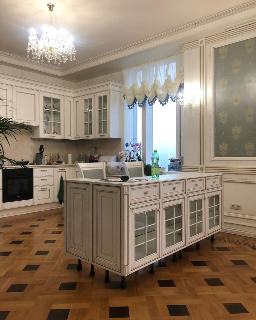Светлая классическая кухня с островом-витриной — общий вид