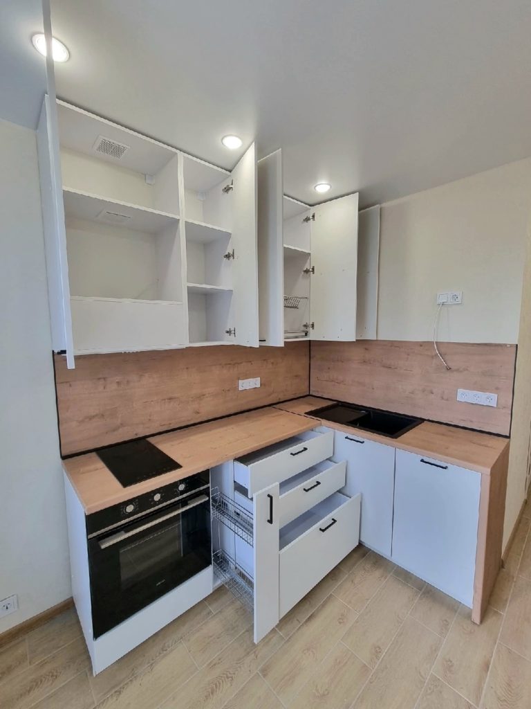 Открытые ящики, выдвижная корзина и верхние шкафы небольшой кухни
